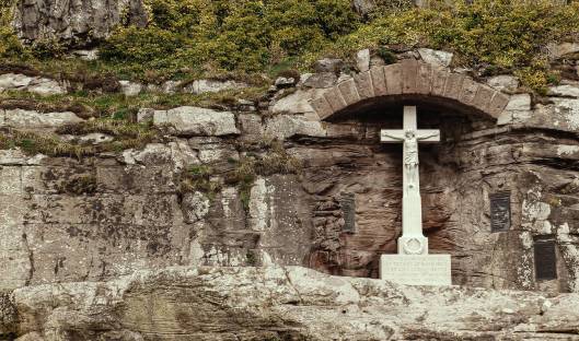 white concrete cross on gray rock formation